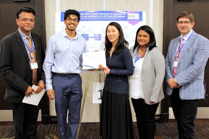 Dr. Hamid presenting a certificate to participants who presented posters