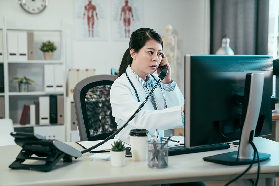 Physician in her office on the phone