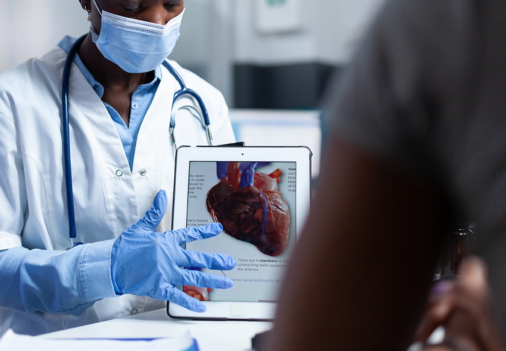 Cardiologist showing image of heart to patient