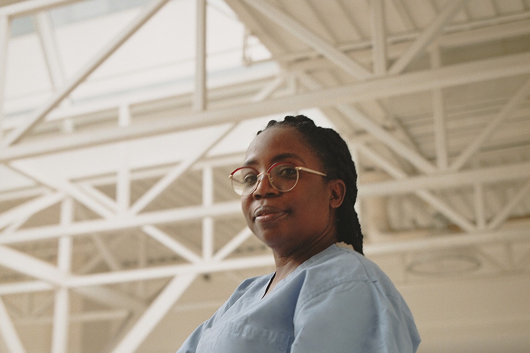 Side profile of a nurse in scrubs smiling at the camera