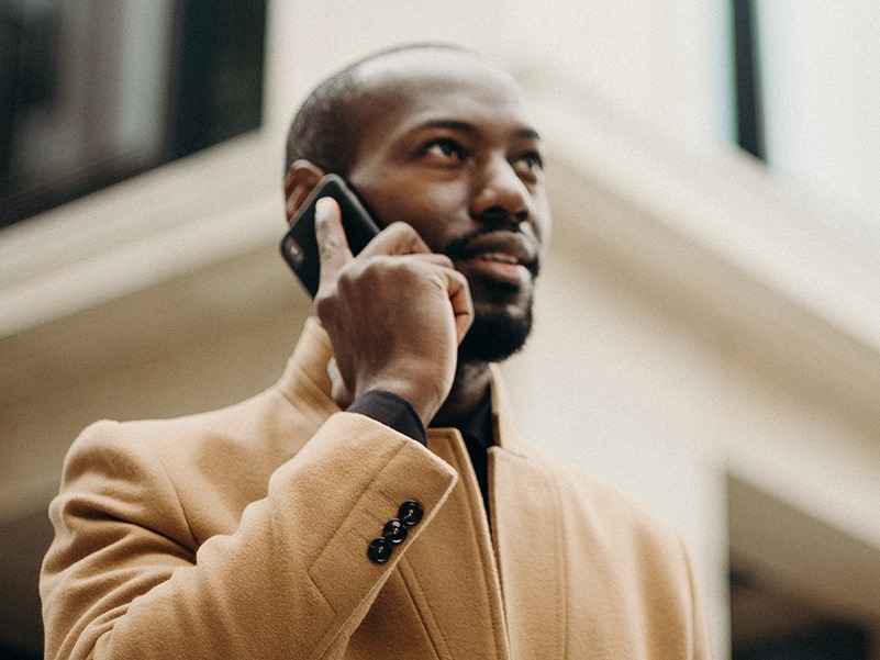 Man speaking on his cell phone, outside with coat on