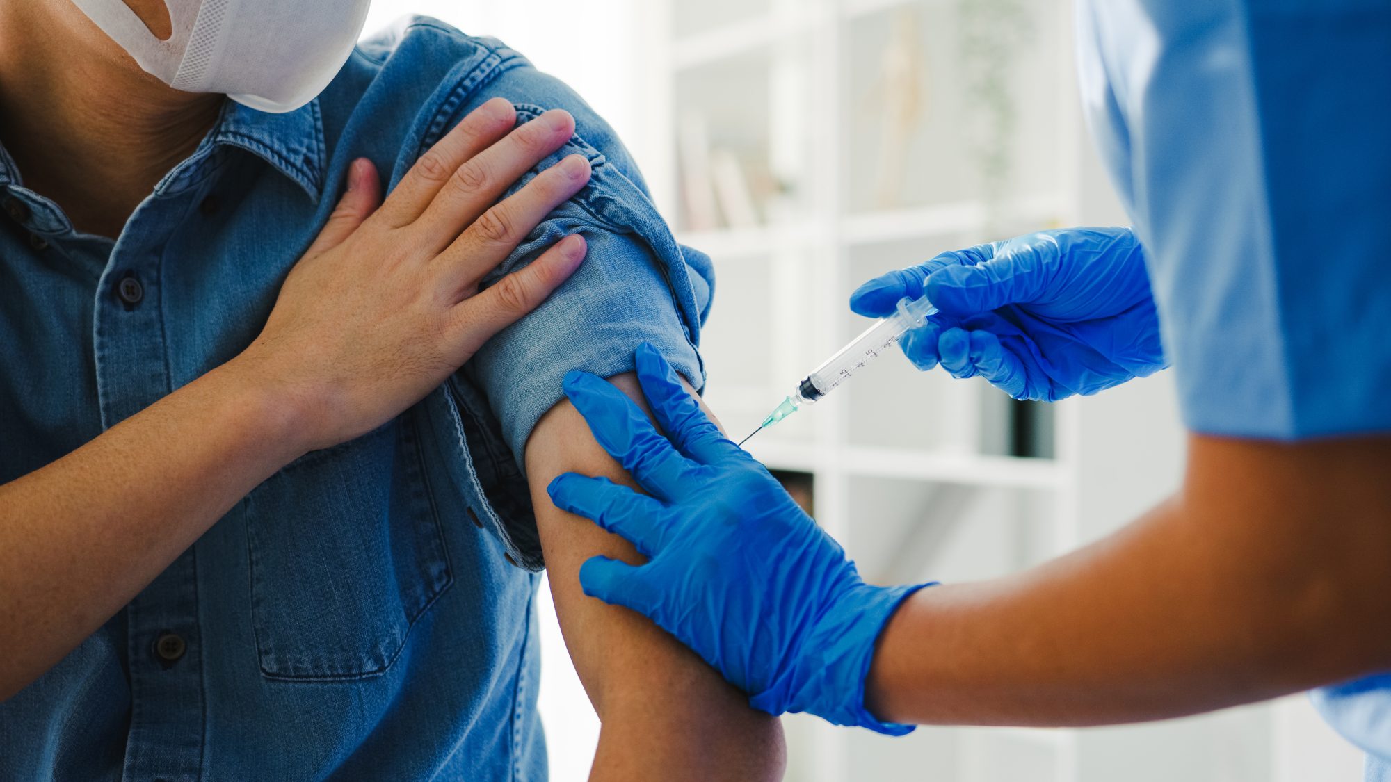 Patient holding rolled up sleeve while getting vaccinated